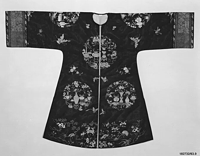Black silk-gauze woman's jacket laid flat, embroidered with round medallions of antique vessels and with patterned bands on the wide sleeves